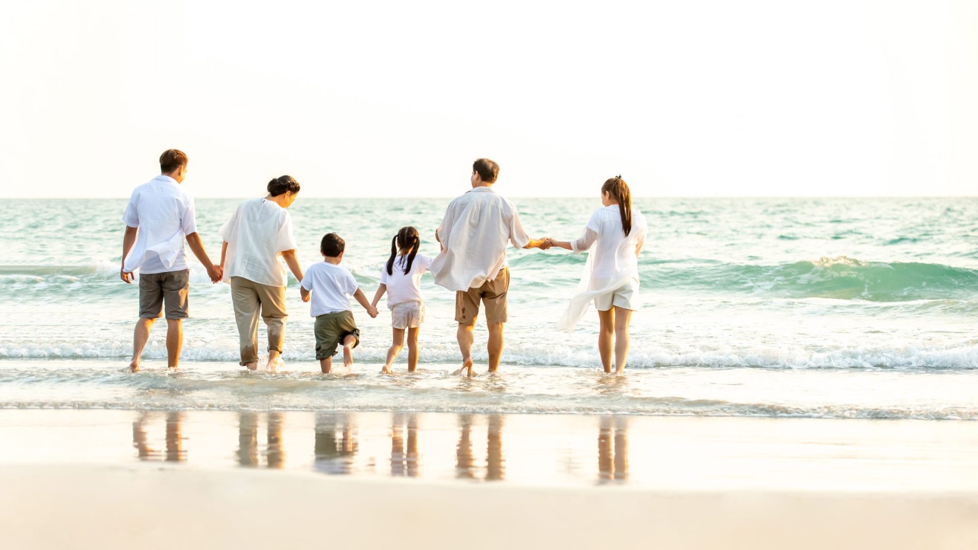 Rear,View,Of,Happy,Multi,Generation,Asian,Family,Relaxing,And